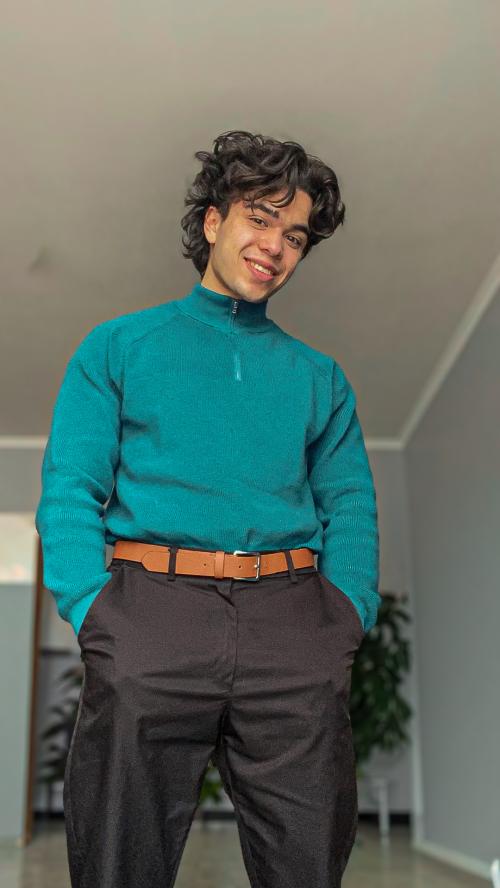 Auteur model Dylan - Portretfoto van mij in een blauwe trui in een woonkamer setting. De foto is genomen door Pete.